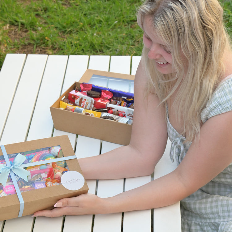 Wife and Small Business Owner - Holding and presenting gift box with bow.